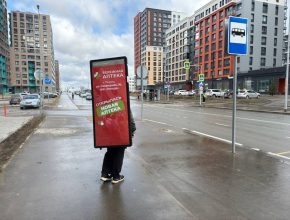 Промоутер с рекламой рюкзаком лайтбоксом за спиной