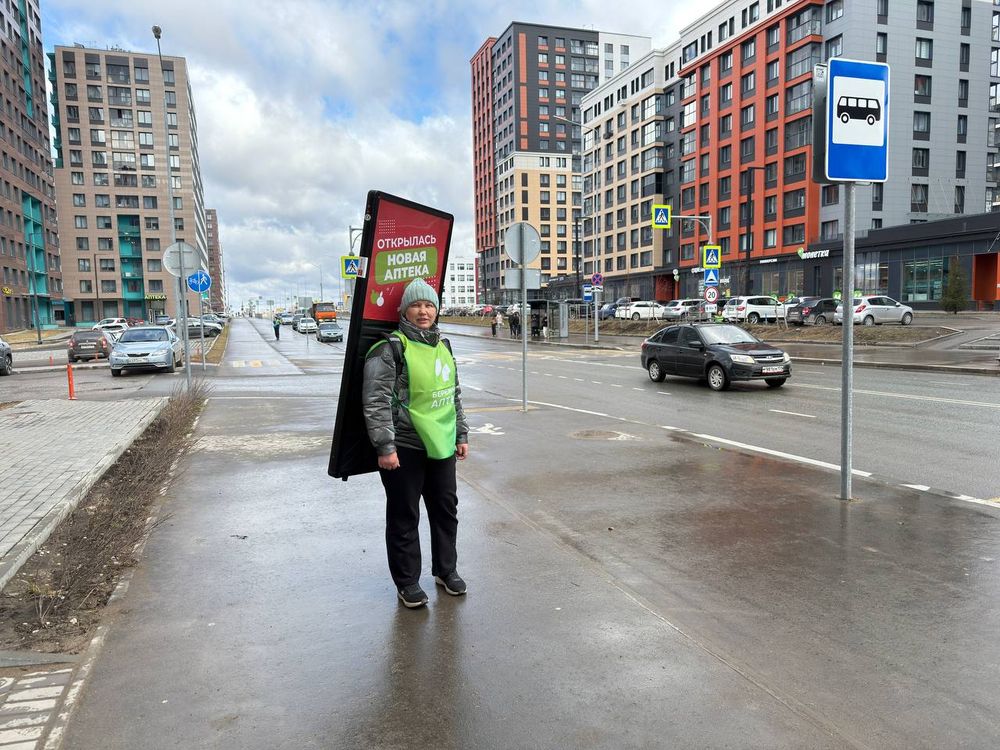 Промоутер с рекламной рюкзаком-панелью на спине